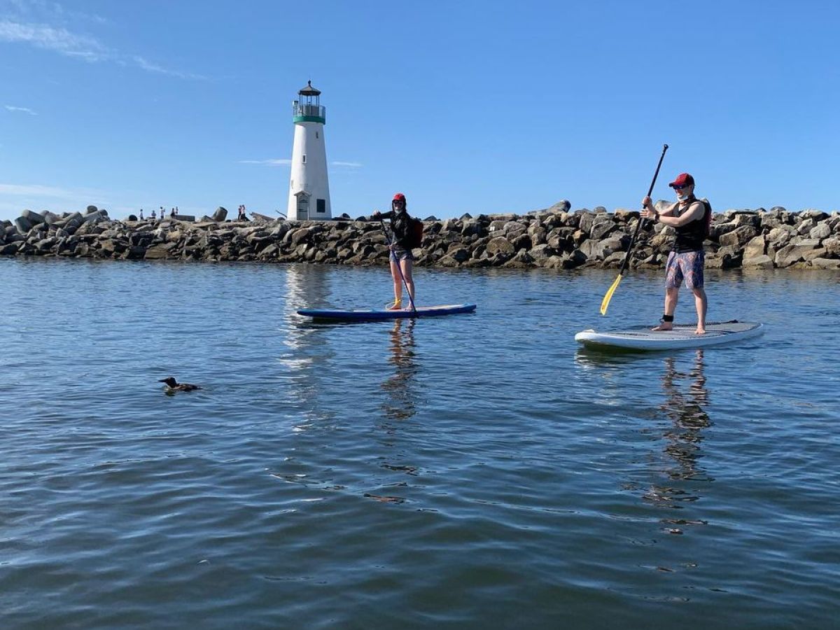 a group of people standing next to a body of water