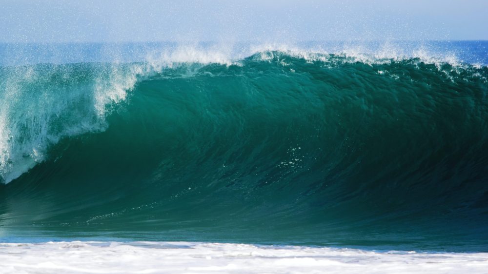 a man riding a wave on a surfboard in the ocean